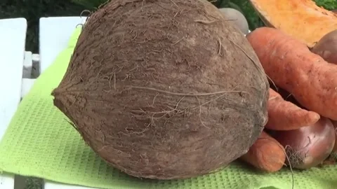 Coconut , carrots and pumpkin on a table (outdoors) Stock Footage 139146572