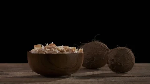 Coconut chips are falling down to wooden bowl Stock Footage 148539208