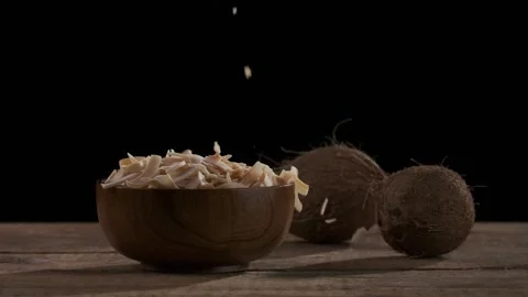 Coconut chips are falling down to wooden bowl Stock Footage 148539273
