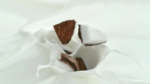 Coconut Chunks Falling into Creamy Milk Making Swirly Splashes in Macro Stock Footage 274355258