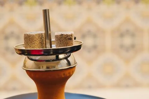 Coconut coals placed on top of a hookah bowl Stock Photos