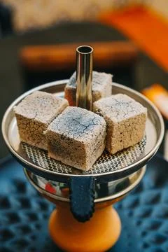 Coconut coals placed on top of a hookah bowl Stock Photos