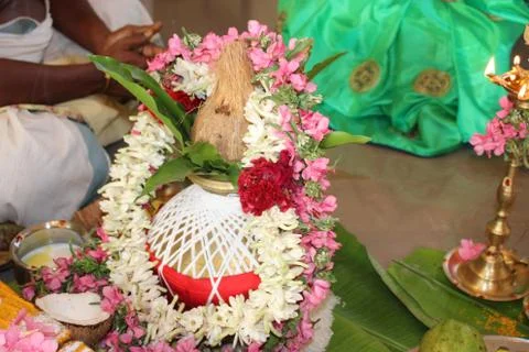 Coconut is covered with white thread and get decorated by flowers and leaves Stock Photos