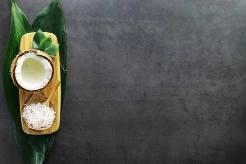Coconut on a dark stone table. Coconut oil. Stock Photos
