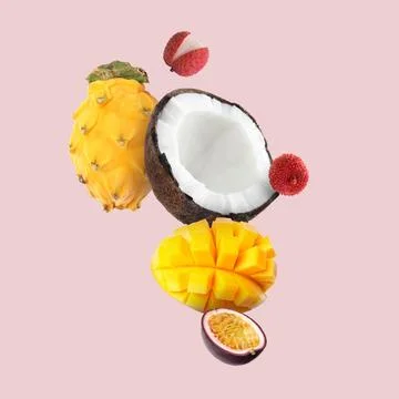 Coconut, dragonfruit, mango, lychees and maracuja in air on pink background.. Stock Photos