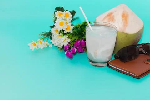 Coconut with drinking straw, notebook and sunglasses on blue background Stock Photos