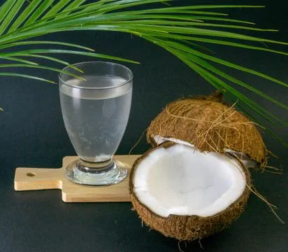 Coconut exotic fruit, two coconut halves in the shell, dark background Stock Photos