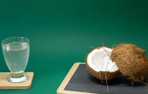 Coconut exotic fruit, two coconut halves in the shell, green background Foto stock
