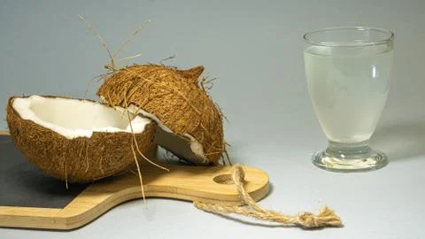 Coconut exotic fruit, two halves of fruit shell on a stone board kitchen with Stock Photos