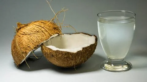 A coconut, an exotic fruit, two halves of the fruit in the shell, close-up Stock Photos