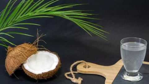Coconut exotic fruit, two halves of the fruit in the shell, a dark background Stock Photos