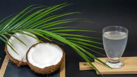 Coconut exotic fruit, two halves of the fruit in the shell, a dark background Stock Photos