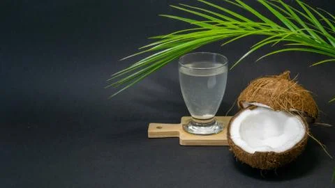 Coconut exotic fruit, two halves of coconut in the shell, a dark background Stock Photos