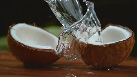 Coconut exploding open with water splashes in dramatic close up slow motion Stock Footage 310128517
