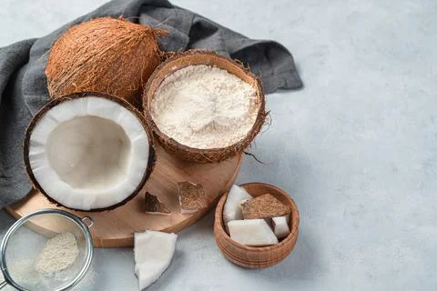 Coconut flour, and coconuts on a gray background. Side view, copy space. Stock Photos