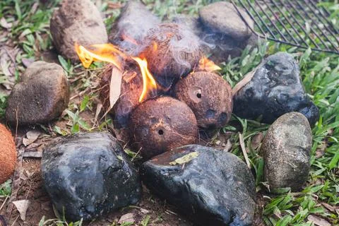 Coconut Husk Fire Surrounded by Rocks Stock Photos