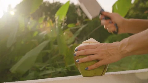 Coconut Juice Splashing in Slow Motion as Knife Hits Fruit on White Surface in Stock Footage 315564424