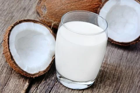 Coconut milk in a glass on rustic table Stock Photos