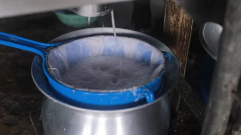 Coconut milk pressing through sieve at market Vídeos de archivo 333095163