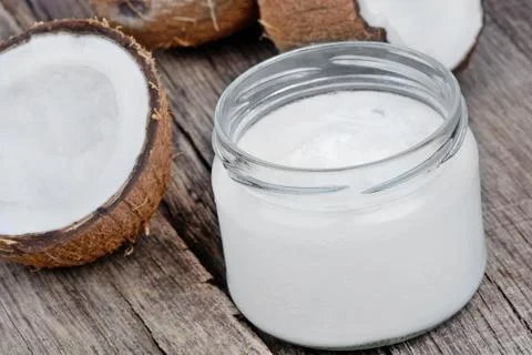 Coconut oil in a jar on rustic table Stock Photos