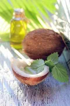 Coconut, palm leaf, soap, aromatic oil on a wooden table Stock Photos