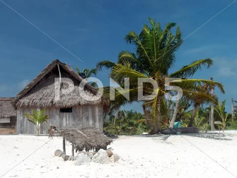 Coconut palm leaves hut on the caribbean beach. Stock Photos