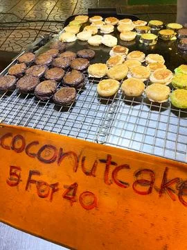 Coconut pancakes displayed on a wire rack at a street food stall in Asia, with a Stock Photos