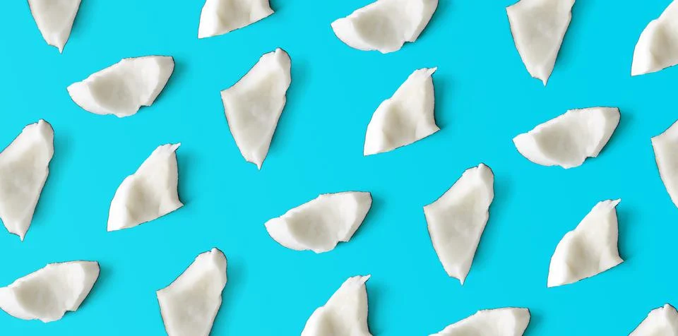 Coconut pieces pattern on blue background, from above Stock Photos