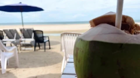 Coconut placed on a table by the beach and full of empty chairs Hun Hin Thailand Stock Footage 201733854