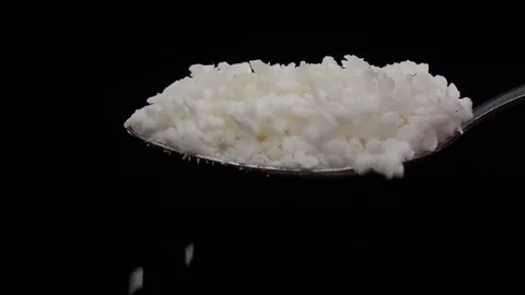 Coconut shaving falling from the iron spoon, black background studio, slow Vidéo 74726008