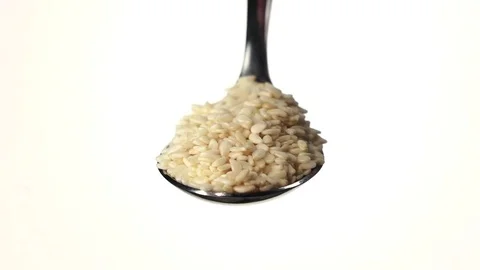 Coconut shaving falling from the iron spoon. White background. Slow motion Stock-Footage 75524320