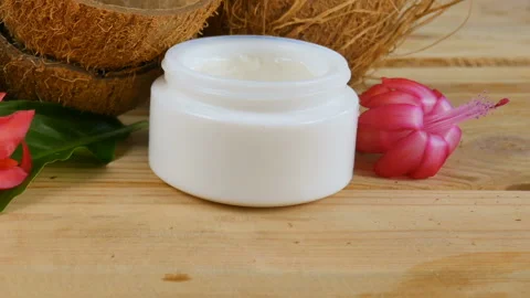 Coconut shells, aloe vera leaves, exotic flowers and cream cosmetic on wooden ba Stock Footage 115582725