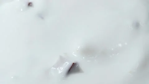 Coconut slices fall into the milk. The spray splashes away. Slow motion. Close-u Видео 144334736