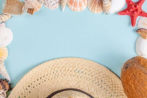 Coconut, starfish, shells, straw hat and bottle with sand on blue background Stockfoto's
