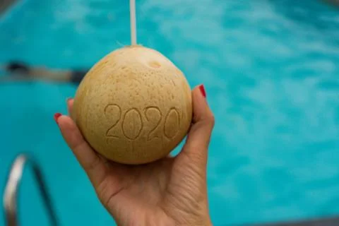 Coconut with straw with 2020 drawing on the beach near the sea Foto stock
