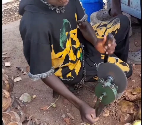 Coconut vendor sharpens machete on grinder in Accra, Ghana Stock Footage 345266451