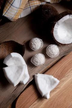 Coconut with white pulp and white candies on wooden background.. Stock Photos