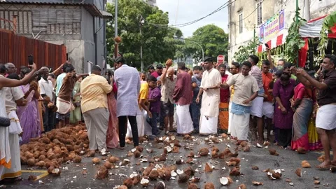 Coconuts are broken as offerings during Thaipusam chariot procession. Видео 318096267