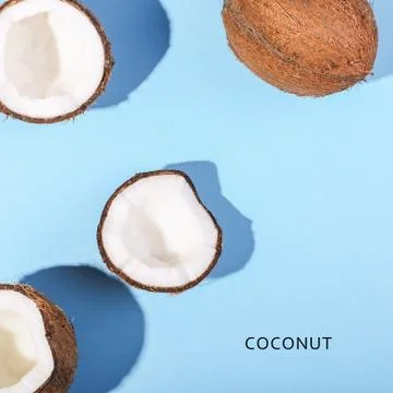 Coconuts on a blue background, top view. Tropical summer concept, copy space. Stock Photos