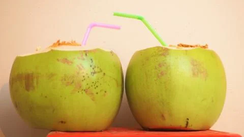 Coconuts ready to be drunk with plastic straws Stock Photos