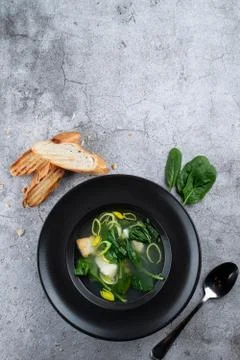 Cod ear soup with fresh spinach and cod pieces on stone background Stock Photos