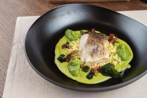 Cod fillet baked with avocado puree and israeli ptitim Stock Photos