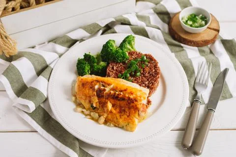 Cod fillet with brown rice and steamed broccoli Stock Photos