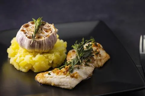 Cod fillet with couscous and roasted garlic Stock Photos