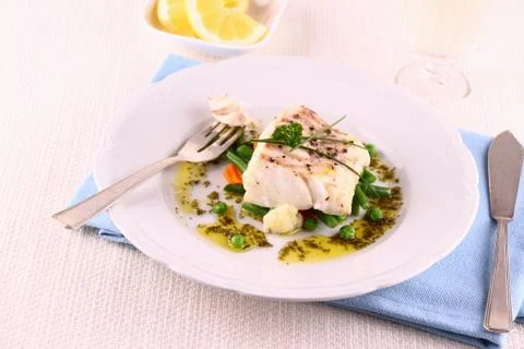 Cod fillet with green beans, peas, parsley, olive oil, wine Stock Photos