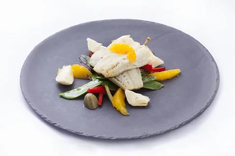 Cod fillet with vegetables and orange pulp Stock Photos