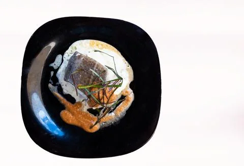 Cod fillets with chives in sauce on white background. Top View Stock Photos