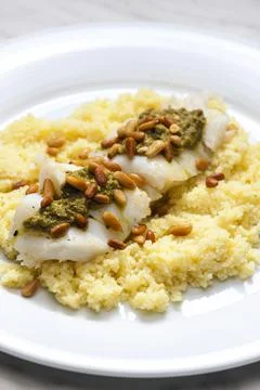 Cod with green pesto and pine seeds with couscous Foto stock