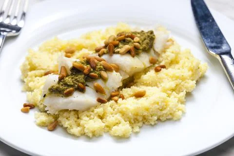Cod with green pesto and pine seeds with couscous Foto stock