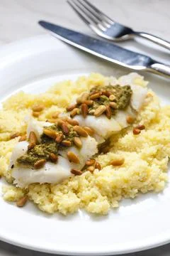Cod with green pesto and pine seeds with couscous Foto stock